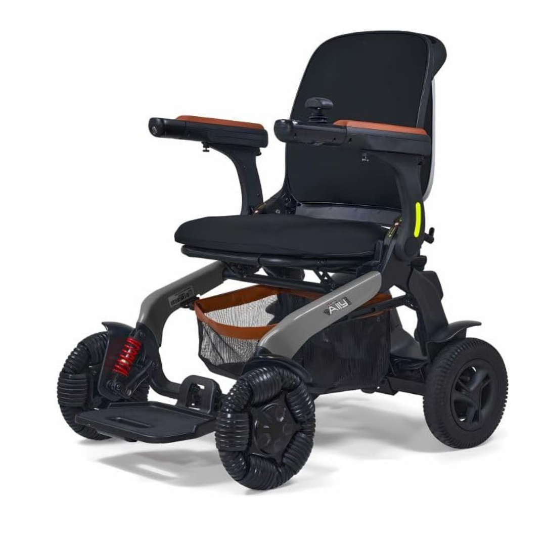 The Golden Tech Ally Pro Smart All-Terrain Power Wheelchair with APP Control features a sleek black and gray frame, cushioned seat and backrest, raised armrests, large rear wheels, omni-directional wheels, and a mesh storage basket.